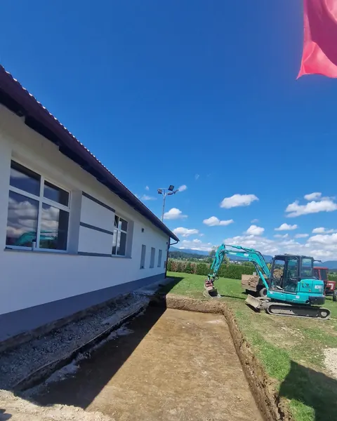 Bager izkopava jarek ob gasilskem domu PGD Babno