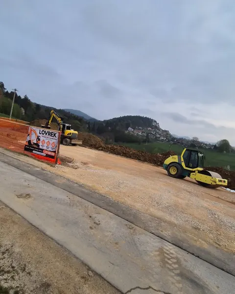 Valjar utrjuje podlago na gradbišču s tablo Lovrek